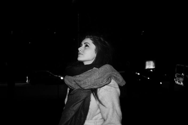Thoughtful young woman wearing warm clothing at night