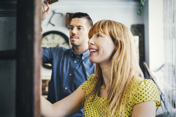 Smiling mid adult woman standing with colleague in store