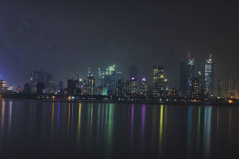 Illuminated city skyline against sky at night