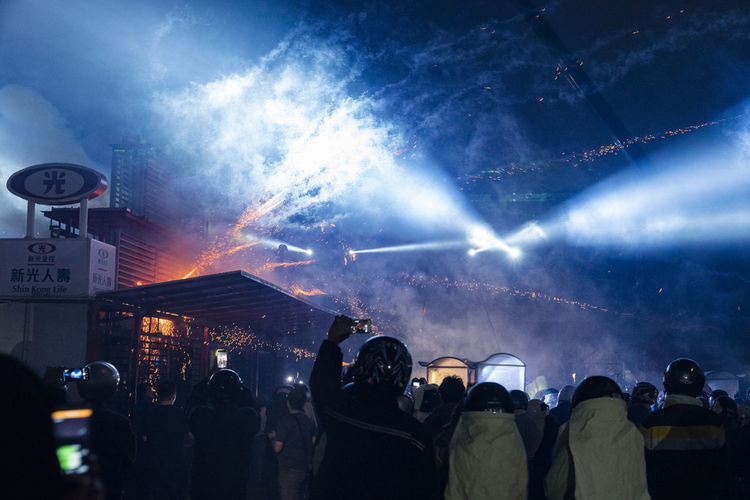 Silhouette people watching firework display at night