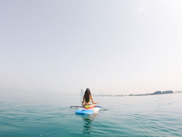 Woman meditating on the paddle board