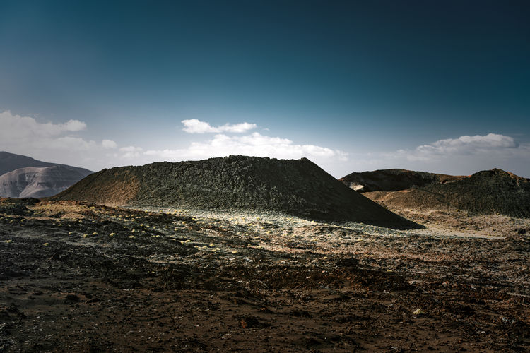 Collapsed volcanic cone in a dark field of multicolored basalt ashes