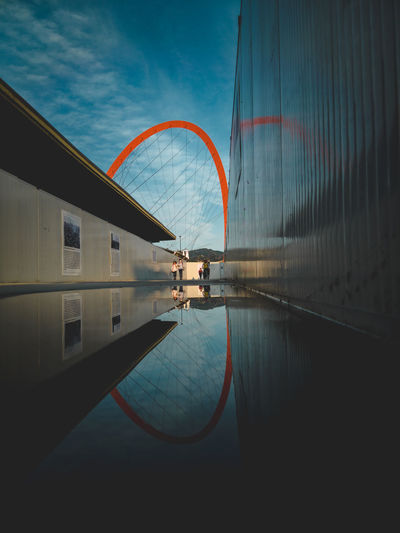 Digital composite image of swimming pool by building against sky