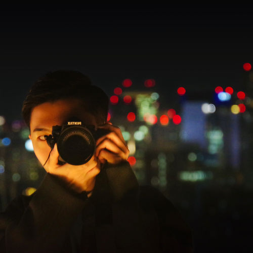 Man photographing with camera at night