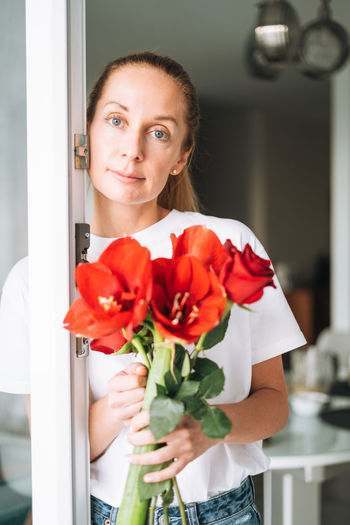 Portrait of young woman with rose bouquet