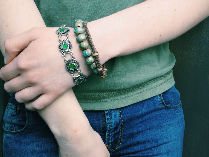 Midsection of woman with green bracelets