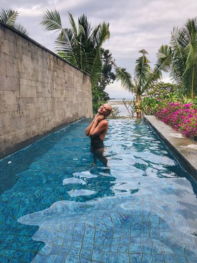 Portrait of woman standing in infinity pool