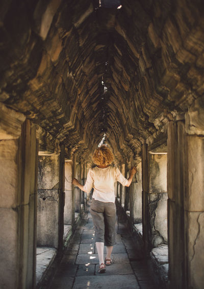 Woman walking in corridor of building