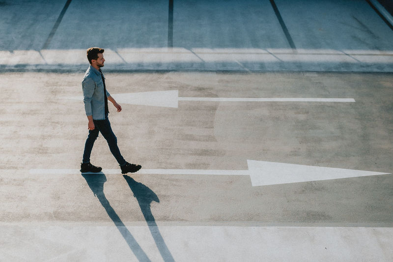 Full length side view of man walking on road