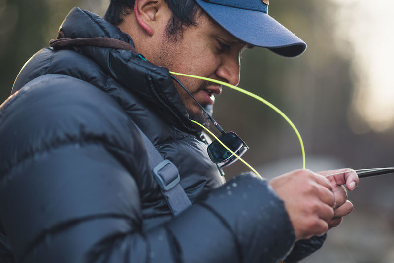 A man inspects his fly-line during a cold morning in maine