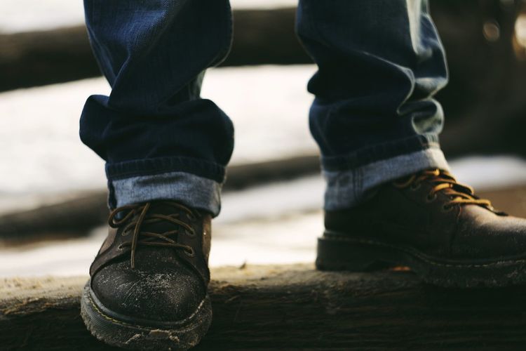 Low section of man wearing jeans and boots