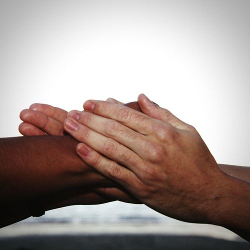 Close-up of human hands against white background