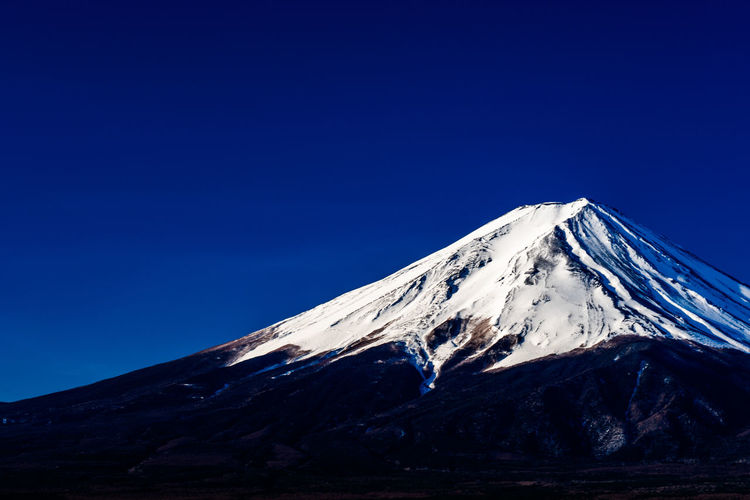 Snowcapped mountain against clear blue sky