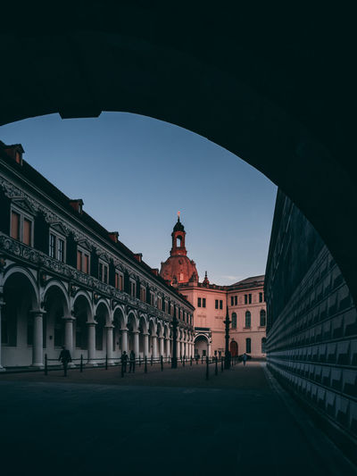Historic building seen through arch in city during sunset