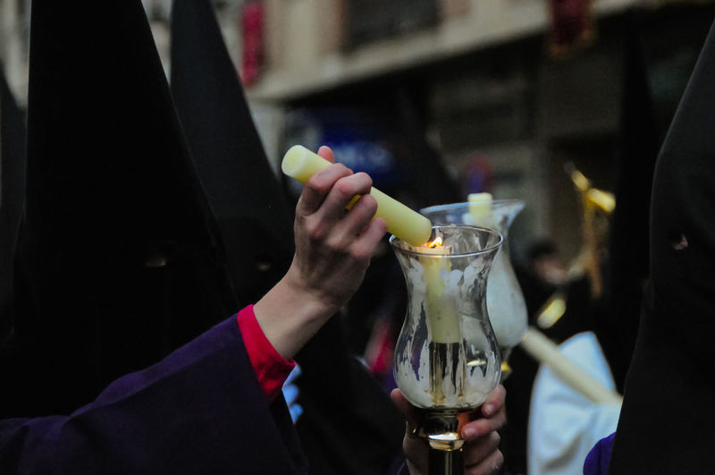 Penitents holding burning candle during holy week at night