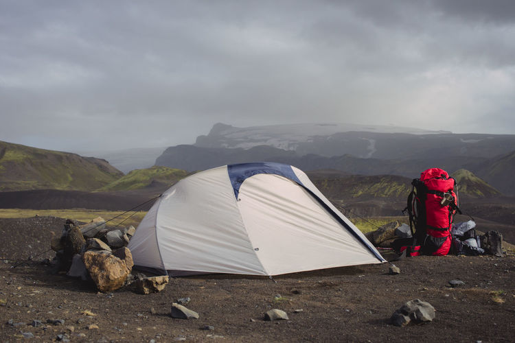 View of tent on mountain against cloudy sky