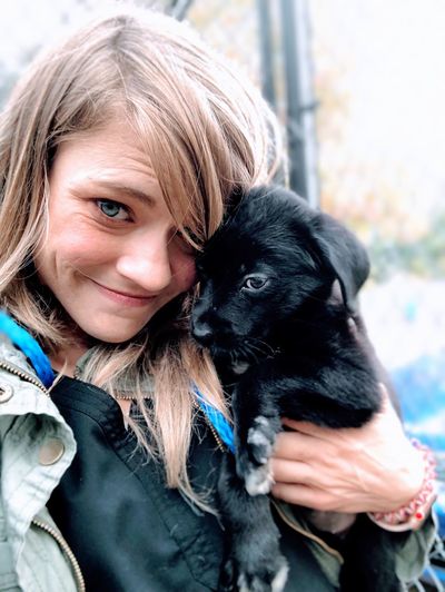 Portrait of woman holding puppy