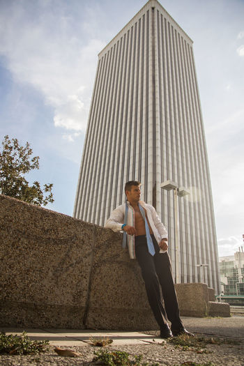 Man standing against modern building in city