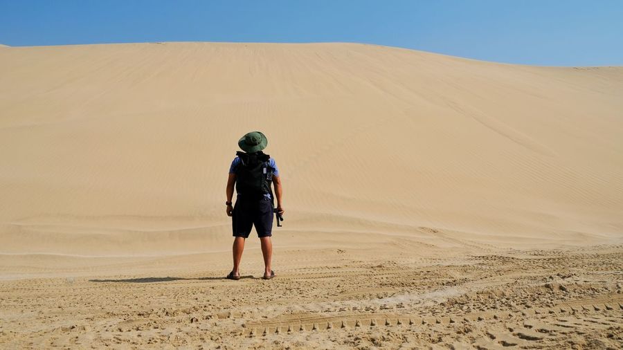 Rear view full length of man standing at desert