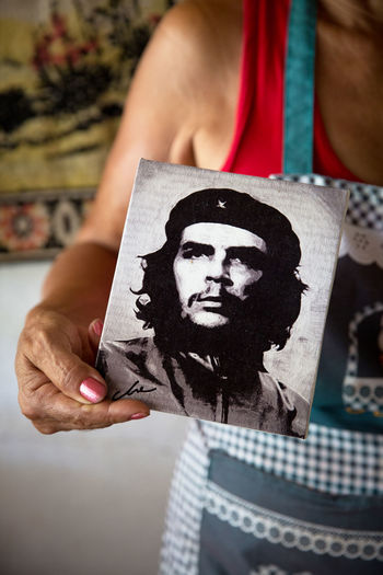 Cropped image woman holding photograph of che guvera at home