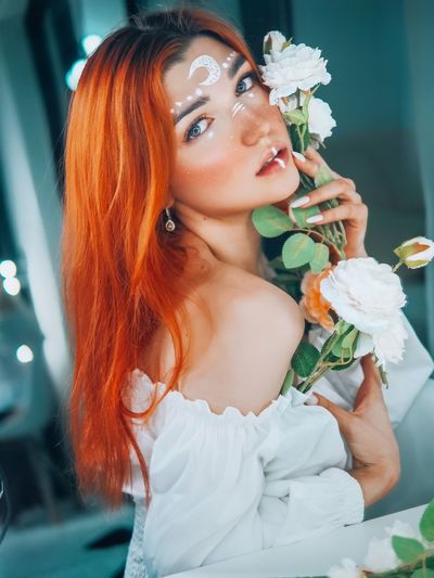 Portrait of beautiful young woman with red flower