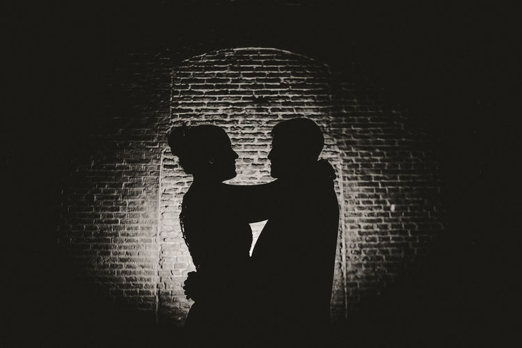 Silhouette man and woman standing against wall