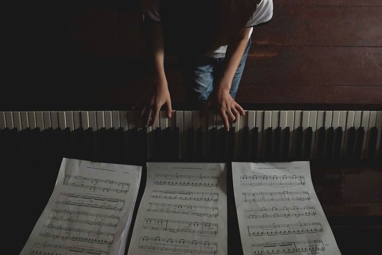 Low section of woman playing piano
