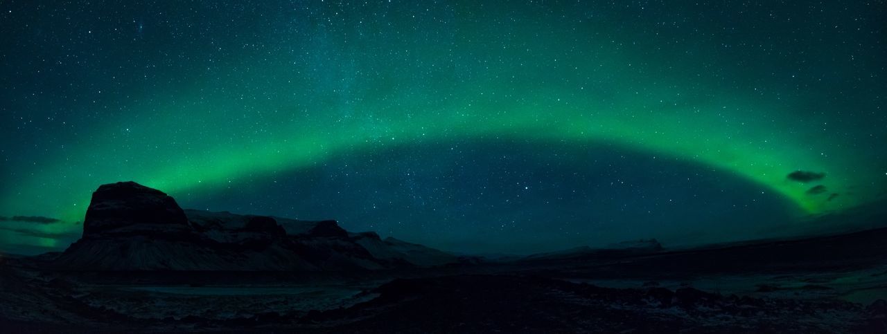 Scenic view of mountains against aurora borealis
