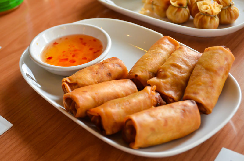 High angle view of springrolls on wooden table