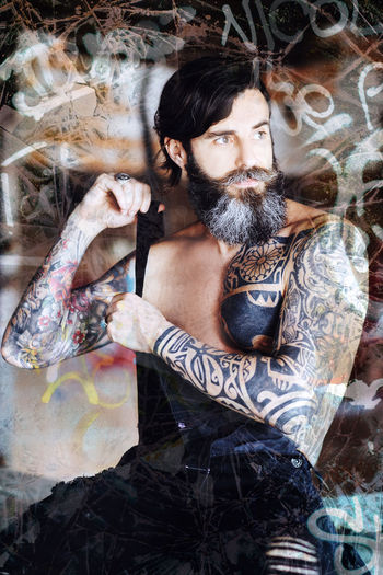 Digital composite image of tattooed man looking away