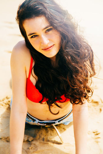 Portrait of smiling young woman lying on beach