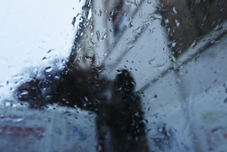 Close-up of wet glass window during rainy season