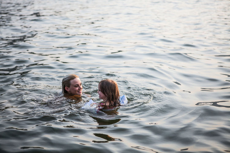 Mother and daughter swimming in sea