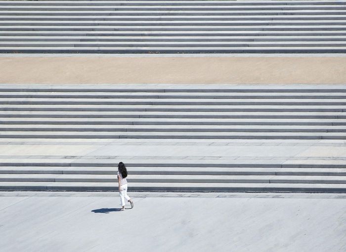 High angle view of woman walking by steps