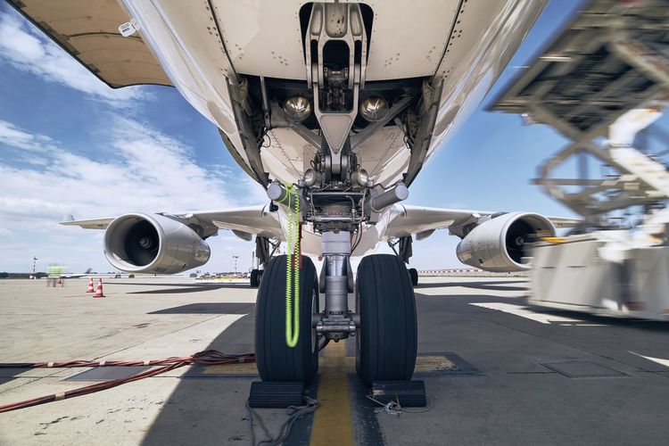 Close-up view of landing gear. loading of cargo to airplane before flight.