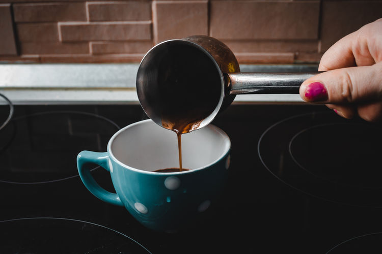 Close-up of hand holding coffee cup