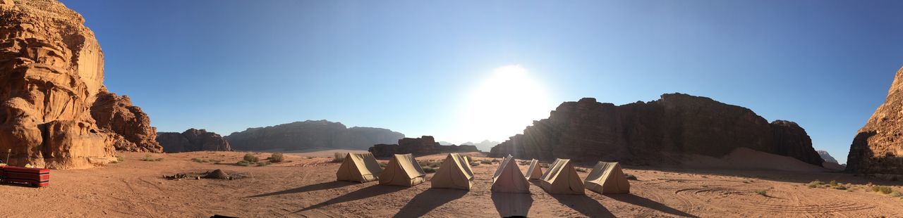 Tents on land against sky during sunny day