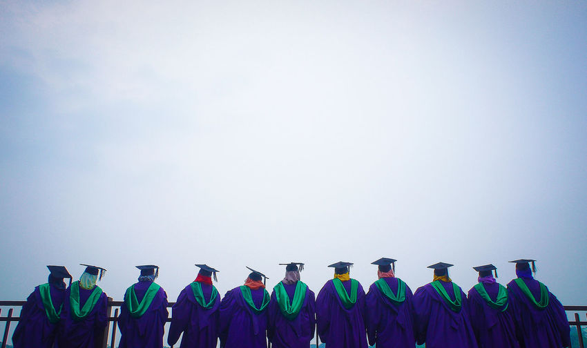 Rear view of people wearing graduation gowns