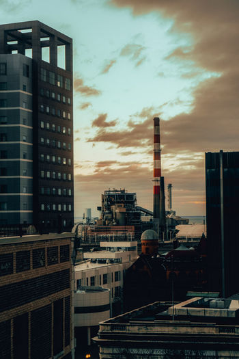Modern buildings against sky during sunset