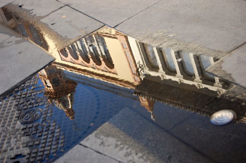 Church reflecting on puddle during sunny day
