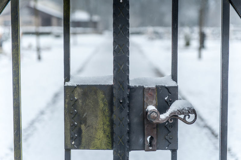 Close-up of snow on metal door handle on cemetery