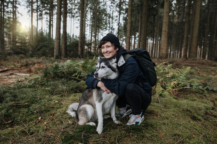 Portrait of woman with dog in forest