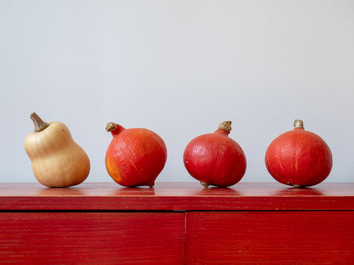 Close-up of apples on table against wall