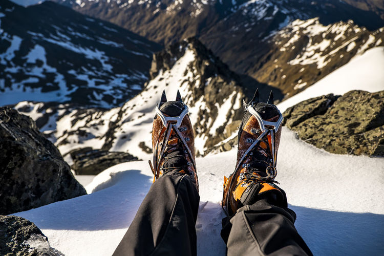 Alpine mountaineering boots with crampons on top of a mountain summit