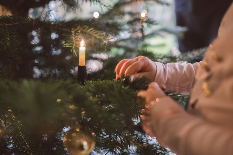 Close-up of girl decorating christmas tree
