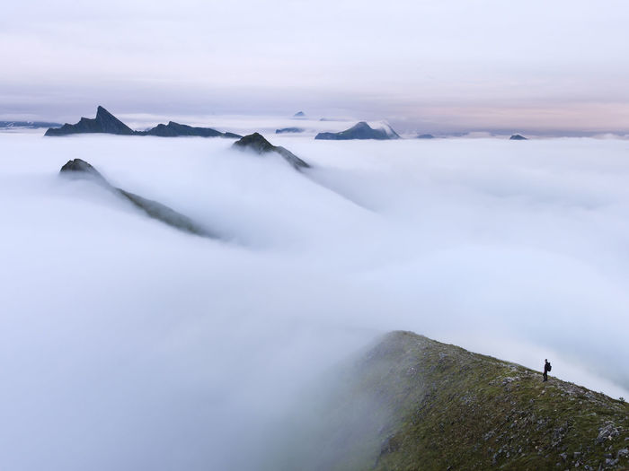 Man in foggy mountain landscape at sunrise