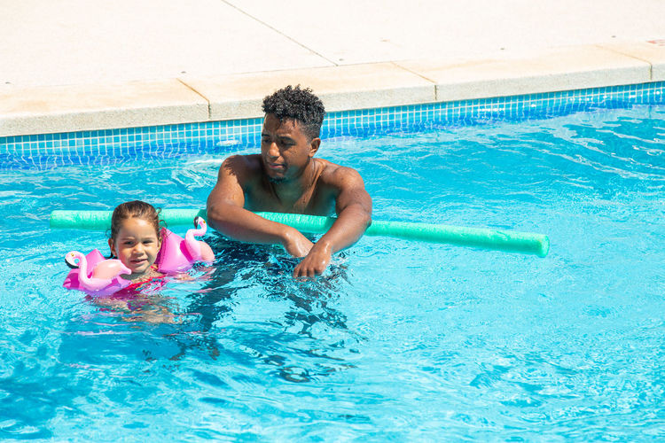 Father and daughter having fun in pool