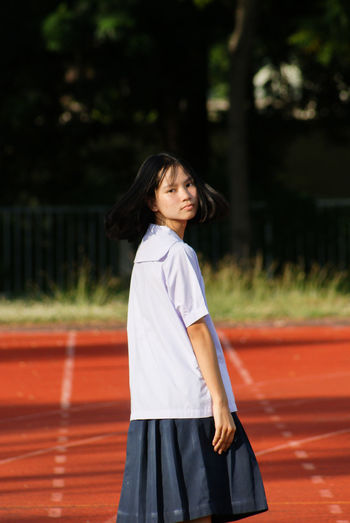 Teenage girl standing at sports field