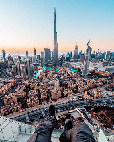 Midsection of modern buildings against sky during sunset