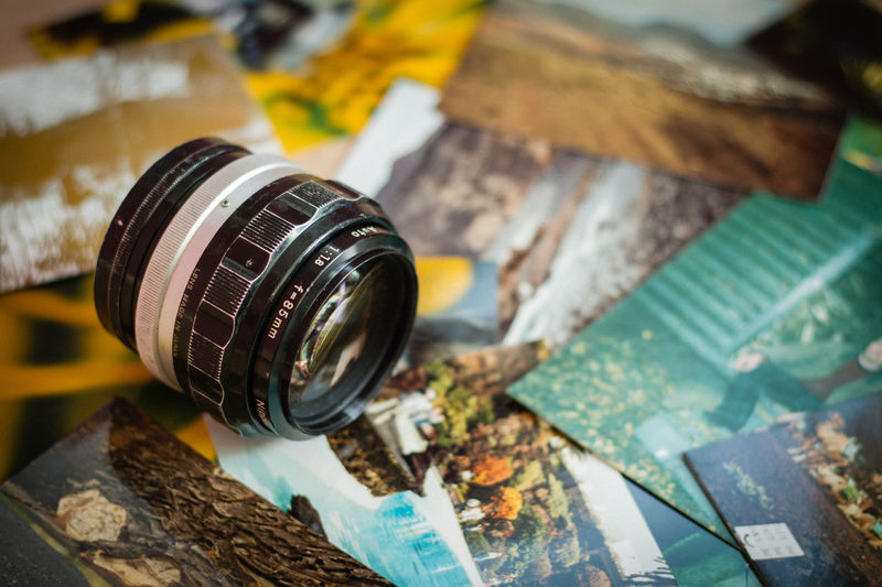 Close-up of lens over photographs